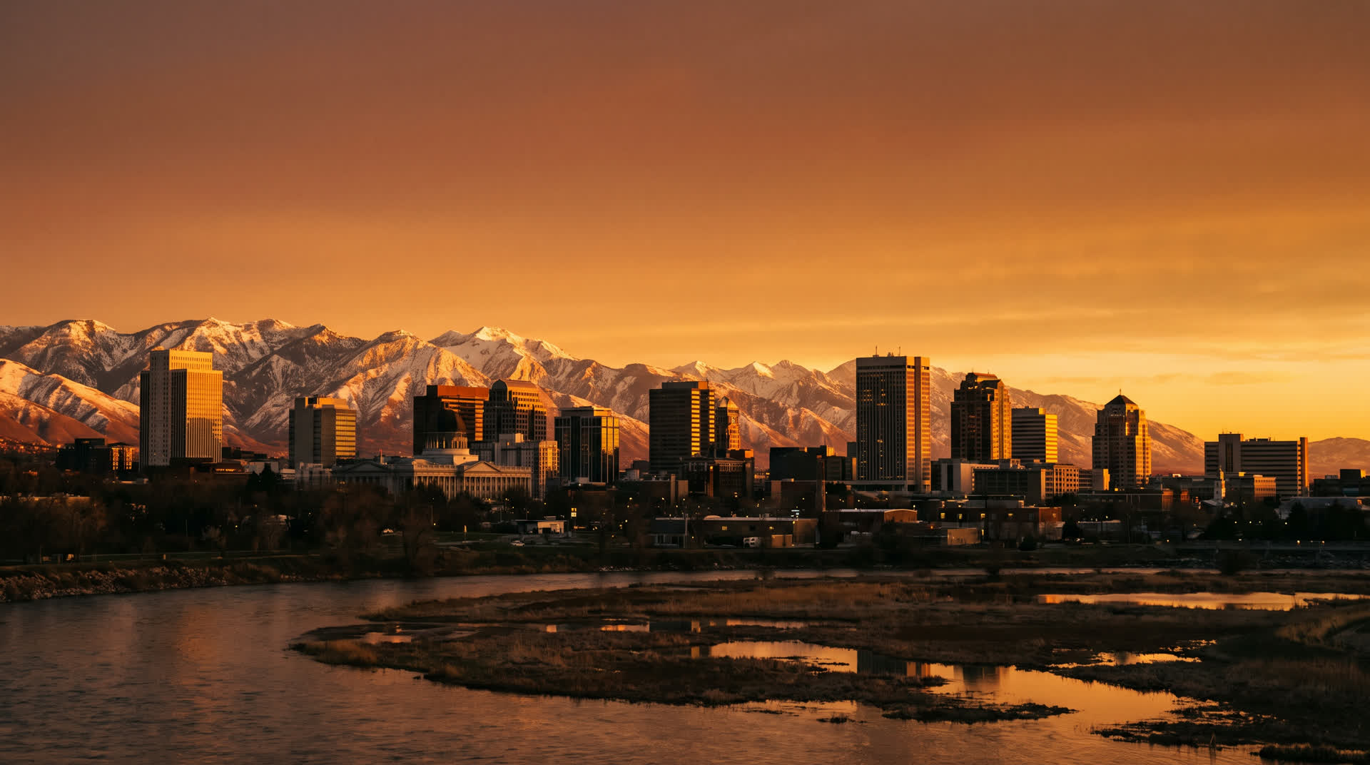 Salt Lake City skyline and snow-capped mountains at golden hour